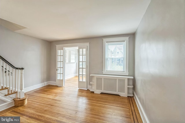 1004 N 67th St, Philadelphia, PA 19151 - empty room featuring radiator, light wood-style floors, stairway, and baseboards