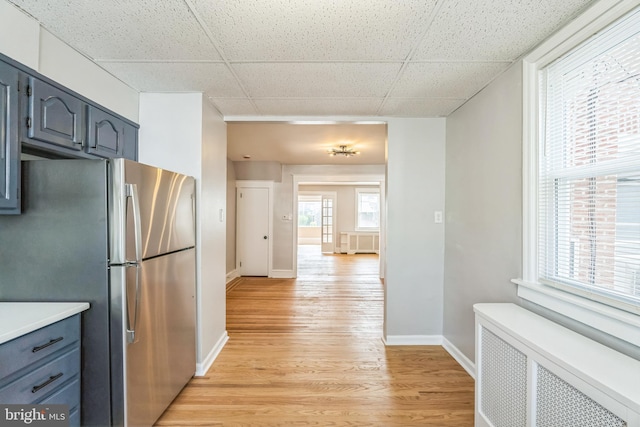 1004 N 67th St, Philadelphia, PA 19151 - kitchen with radiator heating unit, freestanding refrigerator, a paneled ceiling, light wood-type flooring, and baseboards