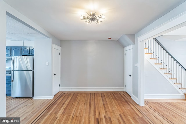 1004 N 67th St, Philadelphia, PA 19151 - unfurnished living room featuring stairs, light wood-style floors, and baseboards