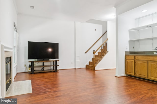 12314 Sour Cherry Way, North Potomac, MD 20878 - unfurnished living room featuring stairway, wood finished floors, a high end fireplace, and bar area