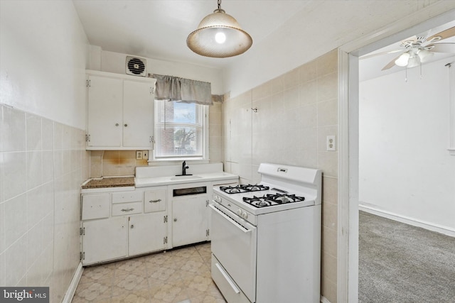 1500 Benner St, Philadelphia, PA 19149 - kitchen featuring white gas range oven, tile walls, white cabinets, a ceiling fan, and a sink