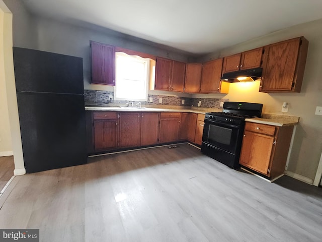 239 Grove St, Bridgeton, NJ 08302 - kitchen featuring black appliances, under cabinet range hood, and wood finished floors