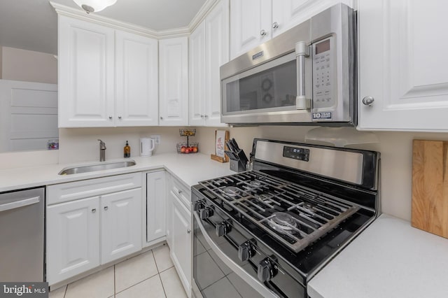 42 Lupton Ave, Woodbury, NJ 08096 - kitchen with stainless steel appliances, white cabinetry, light tile patterned floors, and light countertops