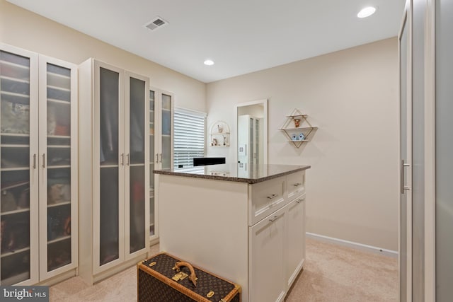 3750 Christopher Day Rd, Doylestown, PA 18902 - kitchen featuring dark stone counters, light carpet, a center island, glass insert cabinets, and white cabinetry