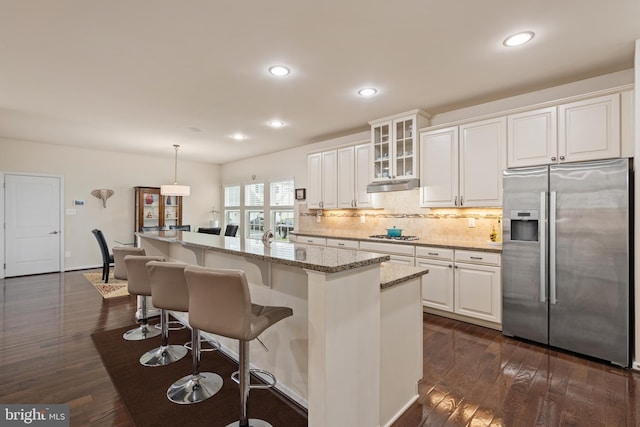 3750 Christopher Day Rd, Doylestown, PA 18902 - kitchen with stainless steel fridge with ice dispenser, decorative backsplash, light stone countertops, white cabinets, and a breakfast bar area