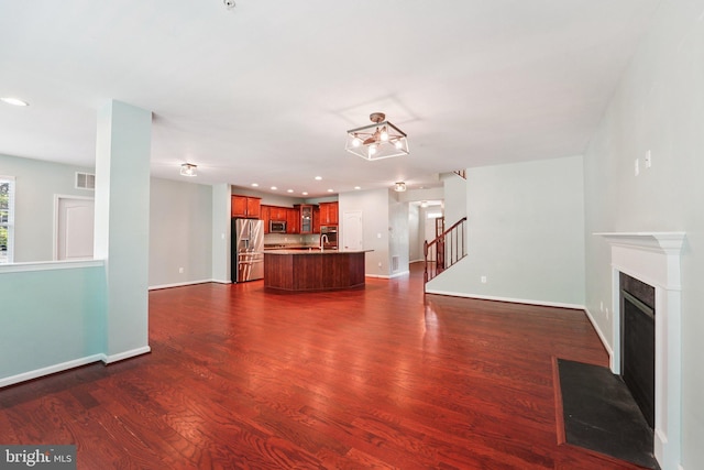 7912 Meridian Dr, Pasadena, MD 21122 - unfurnished living room with stairway, dark wood finished floors, a fireplace with flush hearth, and recessed lighting