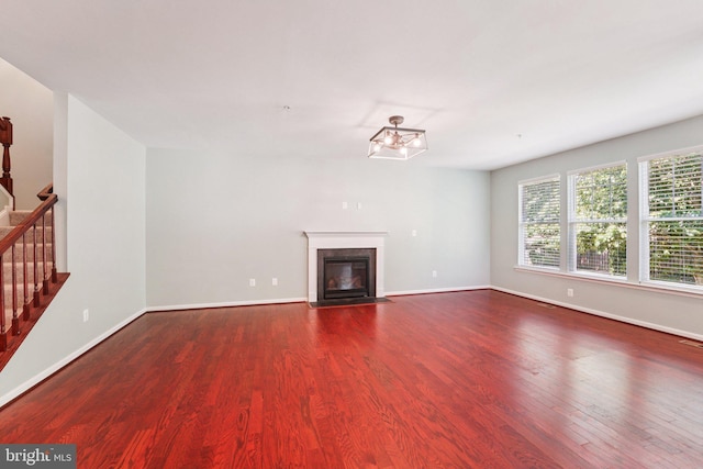 7912 Meridian Dr, Pasadena, MD 21122 - unfurnished living room featuring wood finished floors, stairs, a fireplace with flush hearth, and a chandelier