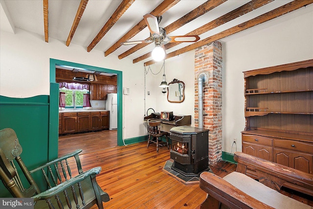 13220 Bank St, Bishopville, MD 21813 - living room with a wood stove, ceiling fan, light wood-type flooring, and beamed ceiling