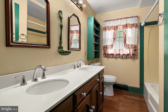 13220 Bank St, Bishopville, MD 21813 - bathroom featuring double vanity, toilet, wood finished floors, and bathtub / shower combination