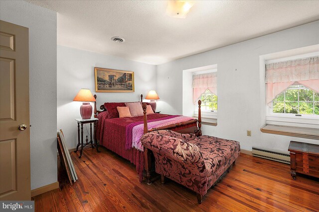 13220 Bank St, Bishopville, MD 21813 - bedroom with a baseboard heating unit, wood-type flooring, and baseboards