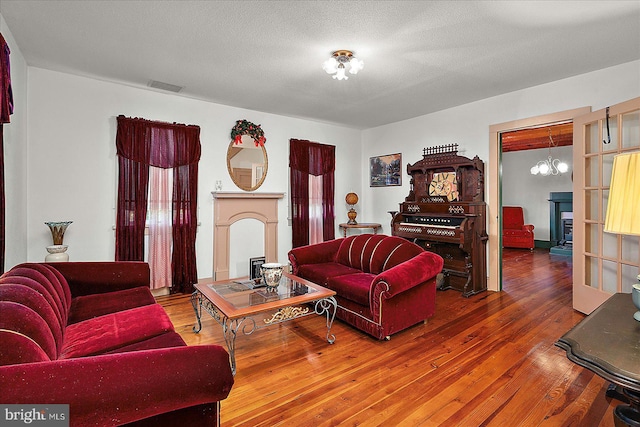 13220 Bank St, Bishopville, MD 21813 - living room featuring a fireplace, a chandelier, and hardwood / wood-style flooring
