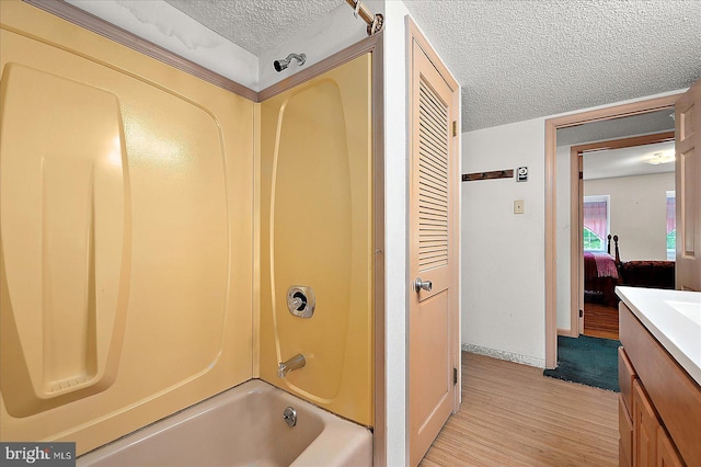 13220 Bank St, Bishopville, MD 21813 - full bath featuring a textured ceiling, vanity, shower / washtub combination, wood finished floors, and baseboards