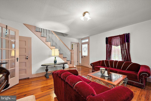 13220 Bank St, Bishopville, MD 21813 - living area with stairway, wood-type flooring, a textured ceiling, and baseboards