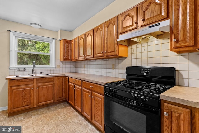 3415 E Market St, York, PA 17402 - kitchen with black range with gas cooktop, under cabinet range hood, a sink, brown cabinets, and decorative backsplash