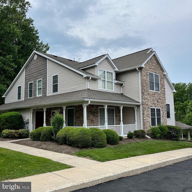 538 Easy St Unit T84, Philadelphia, PA 19111 - view of front of house featuring stone siding, covered porch, a shingled roof, and a front yard