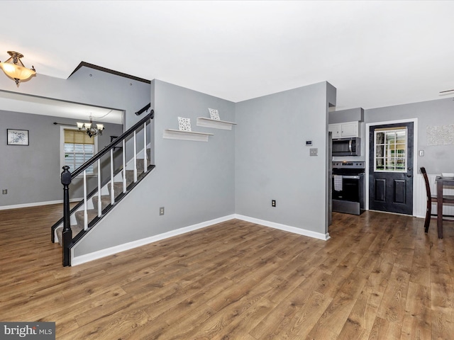 6848 Whistling Swan Way, New Market, MD 21774 - unfurnished living room featuring stairs, wood finished floors, and a chandelier