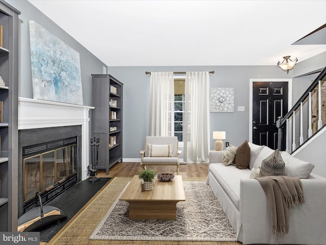 6848 Whistling Swan Way, New Market, MD 21774 - living room with wood finished floors, a glass covered fireplace, and stairway