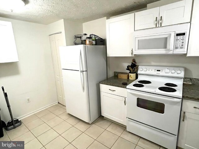13533 Demetrias Way, Germantown, MD 20874 - kitchen with white appliances, dark countertops, white cabinets, light tile patterned floors, and a textured ceiling