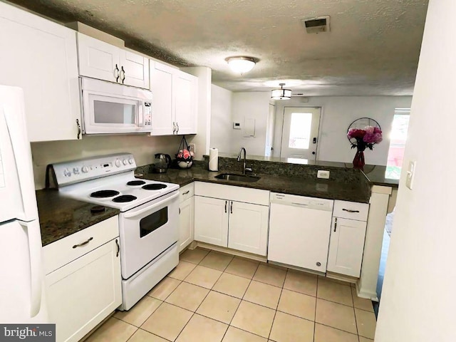 13533 Demetrias Way, Germantown, MD 20874 - kitchen featuring white appliances, dark countertops, white cabinets, light tile patterned flooring, and a peninsula
