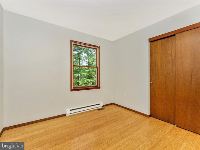 11258 Putman Rd, Thurmont, MD 21788 - unfurnished bedroom featuring baseboard heating, light wood finished floors, a closet, and baseboards