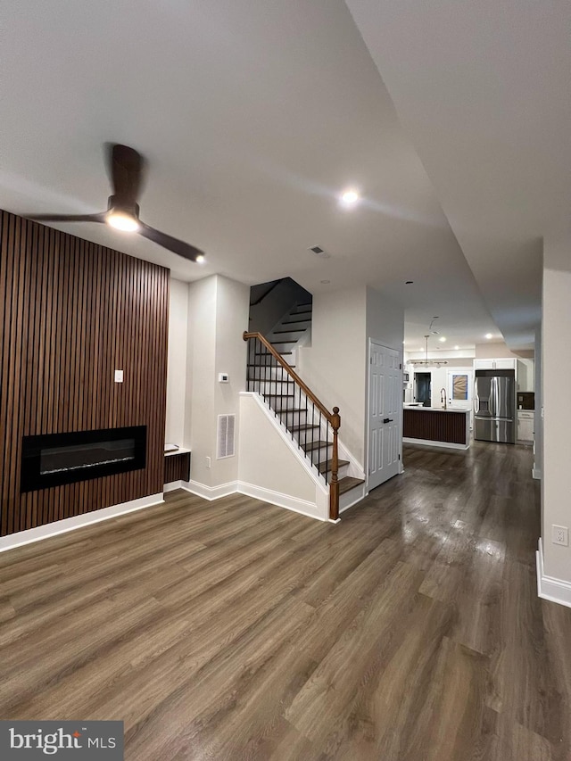 2113 N Longwood St, Baltimore, MD 21216 - unfurnished living room with dark wood finished floors, a ceiling fan, baseboards, recessed lighting, and stairway