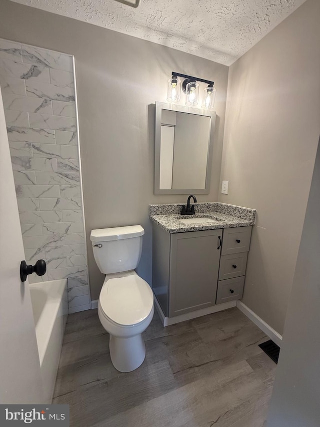 4850 Magpie Ln, Waldorf, MD 20603 - full bath featuring a textured ceiling, wood finished floors, vanity, toilet, and baseboards