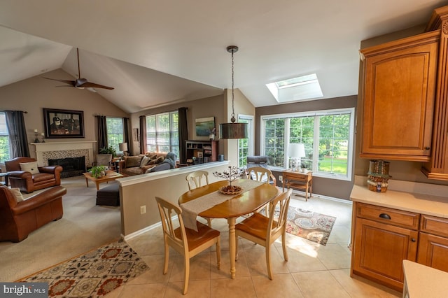 2440 Saddlebrook Rd, Macungie, PA 18062 - dining space featuring a skylight, light tile patterned floors, lofted ceiling, a fireplace, and a ceiling fan