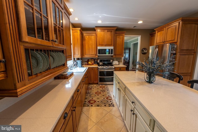 2440 Saddlebrook Rd, Macungie, PA 18062 - kitchen with appliances with stainless steel finishes, light countertops, a sink, brown cabinetry, and glass insert cabinets