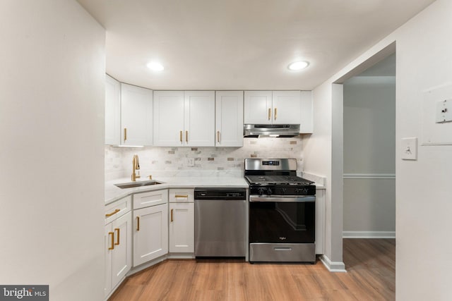 1413 Northgate Sq Unit 13/2A, Reston, VA 20190 - kitchen with appliances with stainless steel finishes, under cabinet range hood, light wood finished floors, white cabinets, and recessed lighting