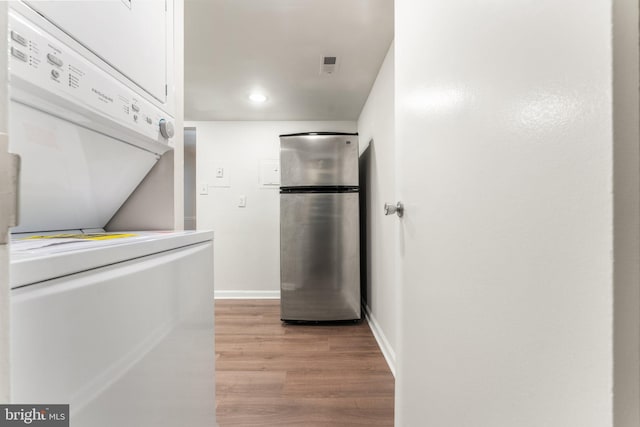 1413 Northgate Sq Unit 13/2A, Reston, VA 20190 - kitchen with freestanding refrigerator, estacked washer and dryer, light wood finished floors, white cabinets, and recessed lighting