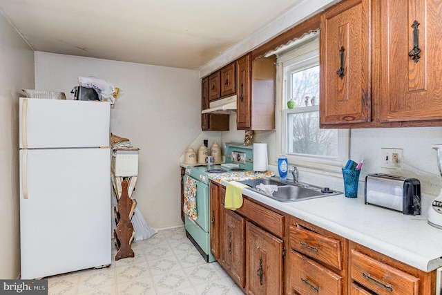 17 Clark St, Duncannon, PA 17020 - kitchen featuring freestanding refrigerator, range, under cabinet range hood, a sink, and brown cabinets