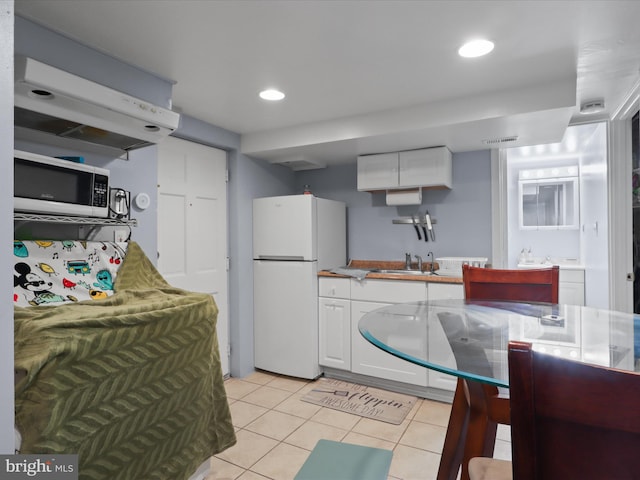 10602 Edgewood Ave, Silver Spring, MD 20901 - kitchen with freestanding refrigerator, stainless steel microwave, white cabinets, light tile patterned floors, and recessed lighting