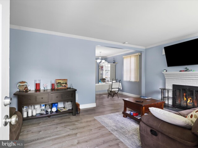 10602 Edgewood Ave, Silver Spring, MD 20901 - living area featuring wood finished floors, crown molding, a brick fireplace, and a chandelier