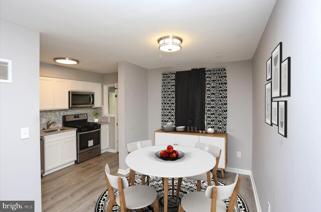 1932 Inverton Rd, Baltimore, MD 21222 - dining space with light wood-style flooring and baseboards