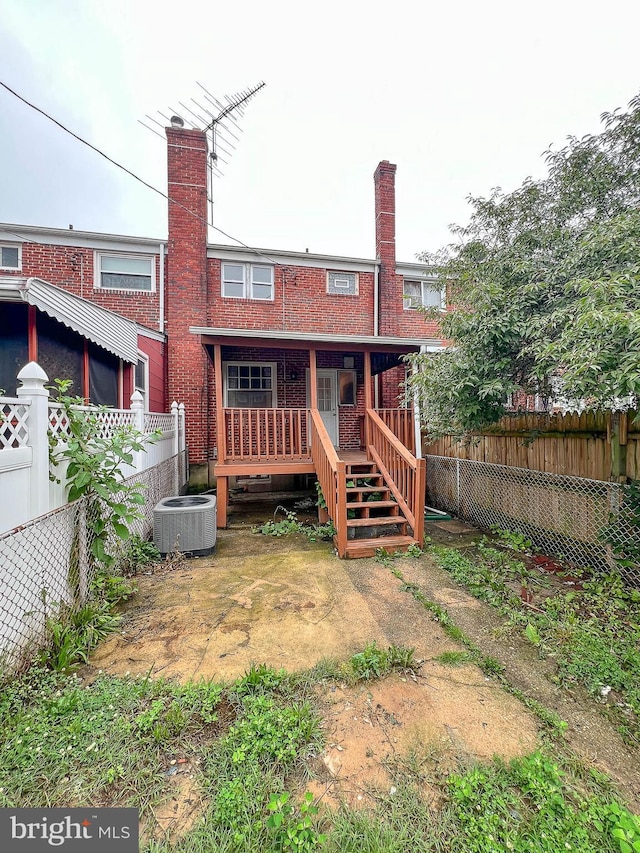 1932 Inverton Rd, Baltimore, MD 21222 - rear view of property with a fenced backyard, brick siding, a wooden deck, and a chimney