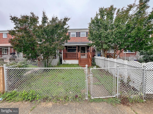 1932 Inverton Rd, Baltimore, MD 21222 - view of front facade with a gate, a fenced front yard, a porch, and brick siding