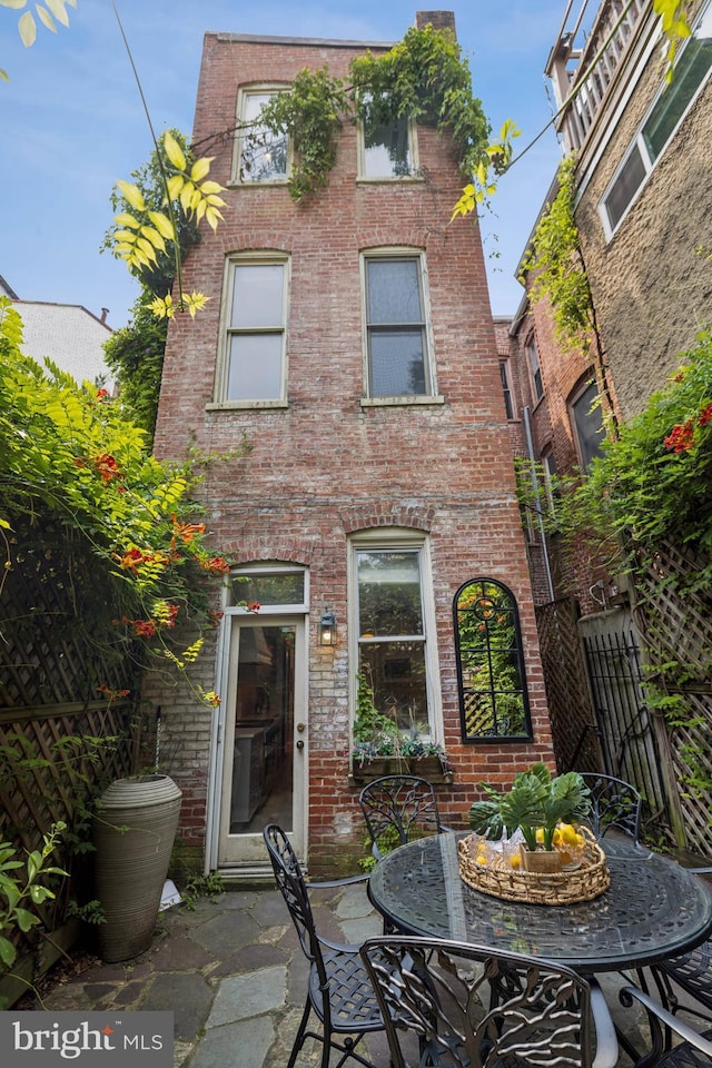 1827 Phelps Pl NW, Washington, DC 20008 - back of property with brick siding, a patio area, and outdoor dining area