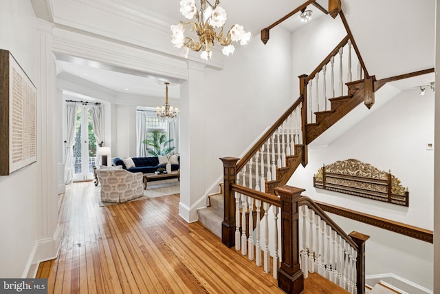 1827 Phelps Pl NW, Washington, DC 20008 - staircase featuring a chandelier, hardwood / wood-style floors, baseboards, and crown molding