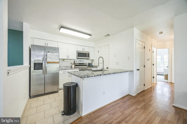 315 Coventry Ct, Mantua, NJ 08051 - kitchen featuring appliances with stainless steel finishes, light stone counters, a sink, white cabinets, and light wood-style flooring