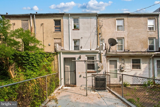 706 Cumberland St, Baltimore, MD 21217 - rear view of house featuring central AC unit, stucco siding, and a patio