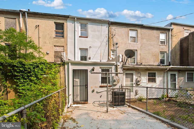 706 Cumberland St, Baltimore, MD 21217 - rear view of house with stucco siding, central air condition unit, and a patio area