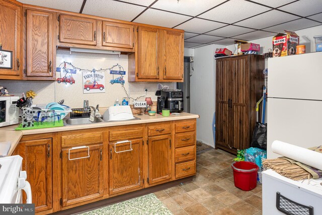 15-17 Locust St, Duncannon, PA 17020 - kitchen featuring a drop ceiling, white appliances, light countertops, and brown cabinets