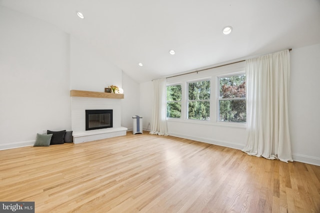 549 E Lafayette Dr, West Chester, PA 19382 - unfurnished living room featuring a glass covered fireplace, wood finished floors, lofted ceiling, and recessed lighting