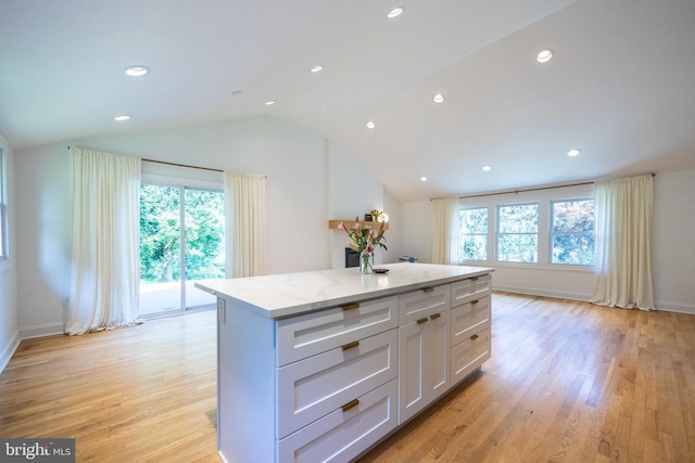 549 E Lafayette Dr, West Chester, PA 19382 - kitchen with lofted ceiling, white cabinets, a kitchen island, light wood-style flooring, and light stone countertops