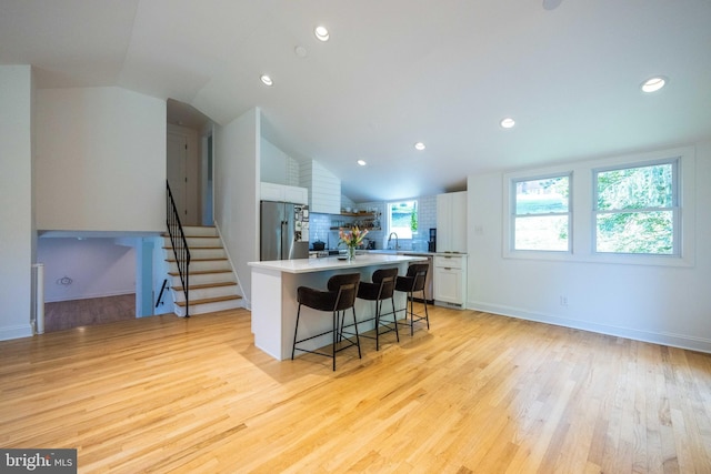 549 E Lafayette Dr, West Chester, PA 19382 - kitchen featuring appliances with stainless steel finishes, white cabinetry, a center island, lofted ceiling, and a kitchen breakfast bar