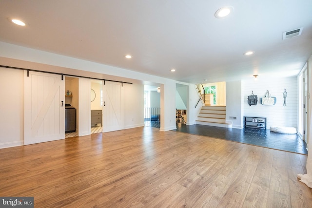 549 E Lafayette Dr, West Chester, PA 19382 - unfurnished living room with a barn door, stairway, light wood finished floors, and recessed lighting