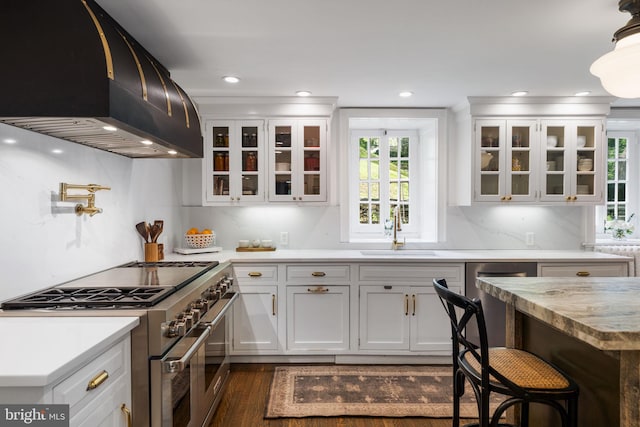 11 Conshohocken State Rd, Gladwyne, PA 19035 - kitchen featuring range with two ovens, wall chimney range hood, a sink, dark wood-style flooring, and white cabinetry
