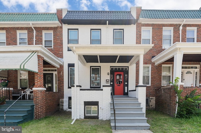 1607 Saint Stephens St, Baltimore, MD 21216 - townhome / multi-family property featuring brick siding, a tiled roof, and covered porch