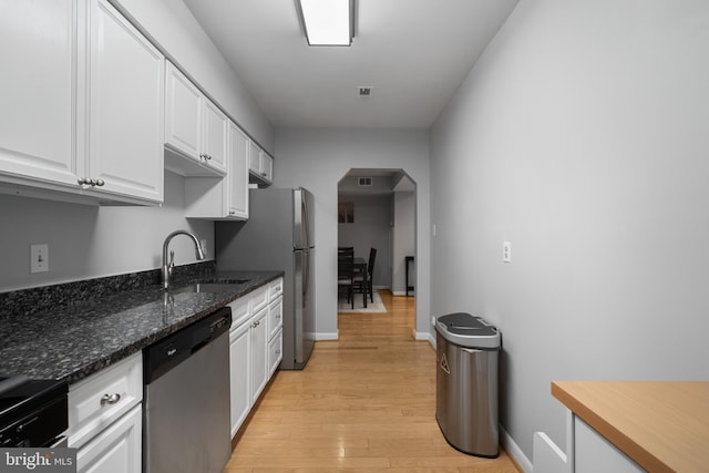 2702 Dartmouth Rd Unit 3, Alexandria, VA 22314 - kitchen with appliances with stainless steel finishes, a sink, arched walkways, white cabinetry, and light wood finished floors