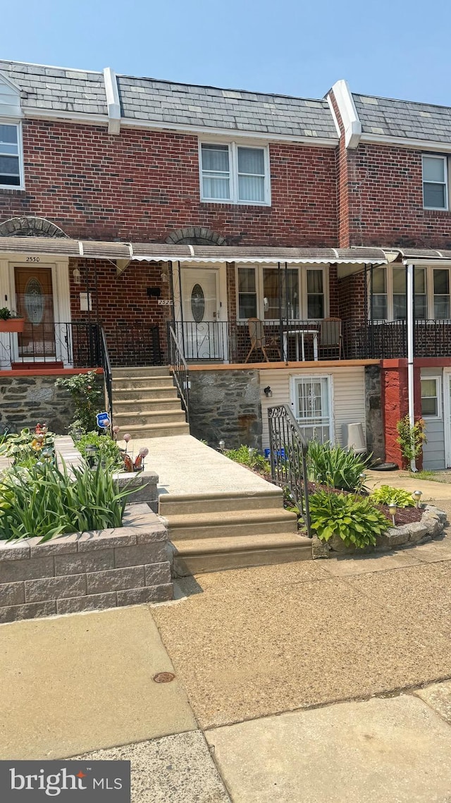 2528 S Claymont St, Philadelphia, PA 19153 - view of front of home featuring a high end roof, mansard roof, brick siding, and covered porch